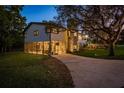 Charming home featuring a stone facade, screened in porch, and a well-manicured lawn at 317 Old East Lake Rd, Tarpon Springs, FL 34688