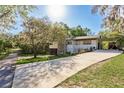 Inviting home with a long driveway, mature trees, carport, and meticulous landscaping at 317 Old East Lake Rd, Tarpon Springs, FL 34688