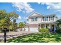 Charming two-story home featuring a lush green lawn, brick driveway, and a three-car garage at 4117 W Platt St, Tampa, FL 33609