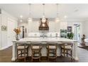 Modern kitchen with a large center island, pendant lighting, white cabinets, and stainless steel appliances at 4117 W Platt St, Tampa, FL 33609