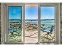 Balcony view with sliding glass doors showing outdoor seating overlooking the waterfront and neighboring community at 4900 Brittany S Dr # 1606, St Petersburg, FL 33715