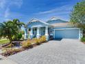 Beautiful blue single-story home with a brick driveway, well-maintained lawn, and an inviting front porch at 5128 Admiral Pointe Dr, Apollo Beach, FL 33572