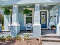 Cozy front porch with seating and decorative hanging plants, creating a warm and inviting entry at 5128 Admiral Pointe Dr, Apollo Beach, FL 33572