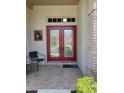 Inviting front door with glass panels and sidelights, complemented by chairs and brick accents at 7392 Meadow Brook Ln, Spring Hill, FL 34606