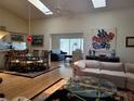 Bright living room with skylights, hardwood floors, and an open floor plan to the kitchen and dining areas at 7392 Meadow Brook Ln, Spring Hill, FL 34606