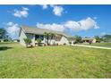 Charming one-story home showcases a well-manicured lawn, light beige exterior, and an attached garage on a bright, sunny day at 7509 Mesa St, North Port, FL 34287