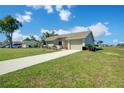Single-story home with an attached garage and concrete driveway, featuring a well-kept lawn and a light beige exterior finish at 7509 Mesa St, North Port, FL 34287
