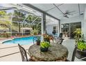 Relaxing screened patio with a table and chairs, adjacent to a sparkling blue swimming pool at 9302 Deer Creek Dr, Tampa, FL 33647
