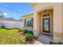 Charming entrance with a glass door, manicured landscaping, and beautiful plants, leading to a welcoming home at 12442 Curry Dr, Spring Hill, FL 34609