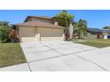 Spacious driveway leading to a two-car garage, surrounded by well-maintained landscaping at 12929 Prestwick Dr, Riverview, FL 33579