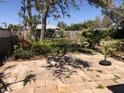 Spacious stone backyard patio surrounded by lush landscaping at 1465 Fundy Rd, Venice, FL 34293