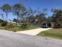 Long private driveway with green, manicured lawn, mature trees, and attractive landscaping at 1465 Fundy Rd, Venice, FL 34293