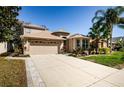 Inviting two-story home with a well-manicured lawn, mature trees, and a two-car garage at 15925 Pond Rush Ct, Land O Lakes, FL 34638