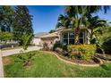 Charming home with a well-manicured lawn, a vibrant garden, and a convenient two-car garage at 15925 Pond Rush Ct, Land O Lakes, FL 34638
