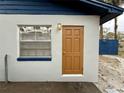 A side view of the home's exterior, showing a window and a brown entry door at 1731 W Perio St, Tampa, FL 33612