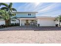 Charming two-story home with a brick driveway and lush tropical landscaping at 200 Driftwood W Dr, Palm Harbor, FL 34683