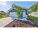 Charming blue home with landscaped front yard, showcasing curb appeal and a two-car garage at 2807 W Granfield Ave, Plant City, FL 33563