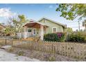 A charming home with a quaint wooden fence, a well-kept lawn, and a cozy front porch at 3000 2Nd N Ave, St Petersburg, FL 33713
