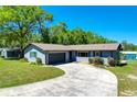 Charming single-story home with a well-maintained lawn and a driveway leading to an attached garage at 37451 Hickory Hill Ln, Dade City, FL 33525