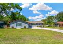 Charming single-story home with a well-maintained lawn and a driveway leading to an attached garage at 37451 Hickory Hill Ln, Dade City, FL 33525