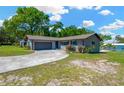 Charming single-story home with a well-maintained lawn and a driveway leading to an attached garage at 37451 Hickory Hill Ln, Dade City, FL 33525