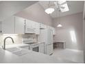 Modern kitchen with white appliances, sleek countertops, and a vaulted ceiling with skylight at 39650 Us Highway 19 N # 615, Tarpon Springs, FL 34689