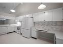 Well-equipped kitchen featuring white cabinetry, appliances, and an adjacent eat-in area at 39650 Us Highway 19 N # 615, Tarpon Springs, FL 34689