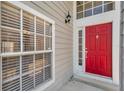 Bright red front door with classic hardware and sidelight window at 5159 Sterling Manor Dr, Tampa, FL 33647