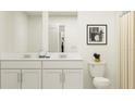 Bathroom featuring a double sink vanity, white cabinets, and framed artwork at 5161 Benjamin Eric St, Zephyrhills, FL 33541