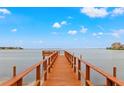 Waterfront view from end of long, private wooden dock with expansive ocean views under a partly cloudy sky at 5625 Escondida S Blvd, St Petersburg, FL 33715