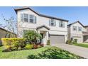 Two-story home featuring blue shutters, a two-car garage, and a well-maintained lawn with green landscaping at 6236 Dutton Dr, Wesley Chapel, FL 33545