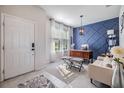The foyer of the home leads to a living room with a stylish accent wall and lots of natural light at 6236 Dutton Dr, Wesley Chapel, FL 33545