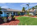 Charming single-story home featuring lush landscaping, a well-manicured lawn, and vibrant mulch beds enhancing curb appeal at 8032 13Th S Ave, St Petersburg, FL 33707