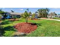 Expansive front yard with lush green lawn and well-maintained landscape beds, showcasing the property's curb appeal at 8032 13Th S Ave, St Petersburg, FL 33707