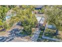 Charming home with a metal roof, lush landscaping, and mature trees in a desirable neighborhood at 8719 N Ola Ave, Tampa, FL 33604