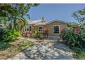 Well-maintained home showcasing its charming facade with lush plantings and beautiful landscaping at 8719 N Ola Ave, Tampa, FL 33604