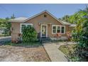 Inviting single-Gathering home featuring a charming front entry with decorative plants and well-maintained landscaping at 8719 N Ola Ave, Tampa, FL 33604