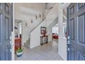 Inviting foyer with tile flooring, a staircase, and a view into the living room, creating a warm and welcoming atmosphere at 9314 Heritage Oak Ct, Tampa, FL 33647