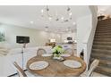 Open concept dining area with a round table, chandelier, and view into the kitchen and living room at 1018 Rose Blossom Ct, Tampa, FL 33613