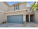 Charming two-story townhome with a large garage and a beautiful walkway leading to the front door at 1018 Rose Blossom Ct, Tampa, FL 33613