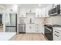 View of the kitchen showcasing stainless steel appliances, quartz countertops, and white cabinetry at 1104 S Lois Ave, Tampa, FL 33629
