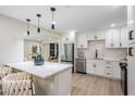 Modern kitchen with quartz countertops, stainless steel appliances, island with seating, and pendant lighting at 1104 S Lois Ave, Tampa, FL 33629