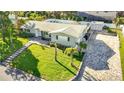 Aerial view of a single-story home with a manicured lawn and a long driveway at 1247 Holiday Dr, Tarpon Springs, FL 34689