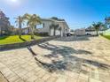 Paver driveway leading to a single-story home with a well-maintained lawn and a shed at 1247 Holiday Dr, Tarpon Springs, FL 34689
