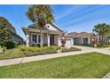 Beautiful single-Gathering home with manicured lawn, colorful landscaping, and a two-car garage at 14885 Caravan Ave, Odessa, FL 33556