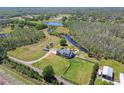 Sprawling estate with a tranquil pond, lush greenery, and a pristine swimming pool at 19530 Barrie Acres Trl, Odessa, FL 33556