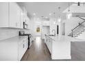 White kitchen featuring stainless steel appliances, quartz countertops and open floor plan at 2039 Longliner Loop, Wesley Chapel, FL 33543