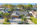 An aerial view of a house with mature trees, a paver driveway, and a charming landscape at 22 Oak Ave, Palm Harbor, FL 34684