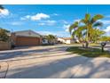 Charming home exterior featuring a paver driveway, mature trees, and lush landscaping at 22 Oak Ave, Palm Harbor, FL 34684