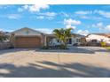 Charming home exterior with stone accents, large paver driveway, mature palms, and a compass above garage at 22 Oak Ave, Palm Harbor, FL 34684